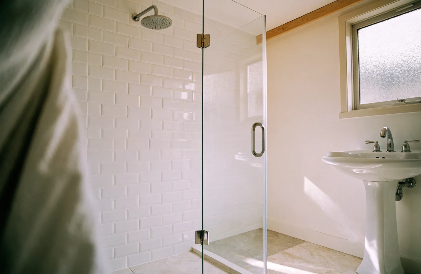 Bright bathroom with streak-free glass shower and polished chrome fixtures after a deep clean