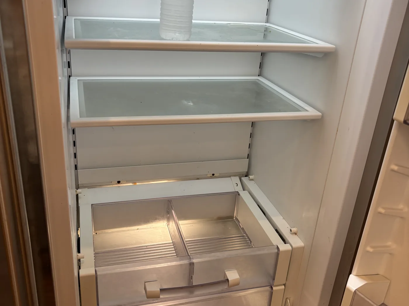Move-out cleaning with the refrigerator cleaned inside and built-in mudroom cubbies emptied and wiped down