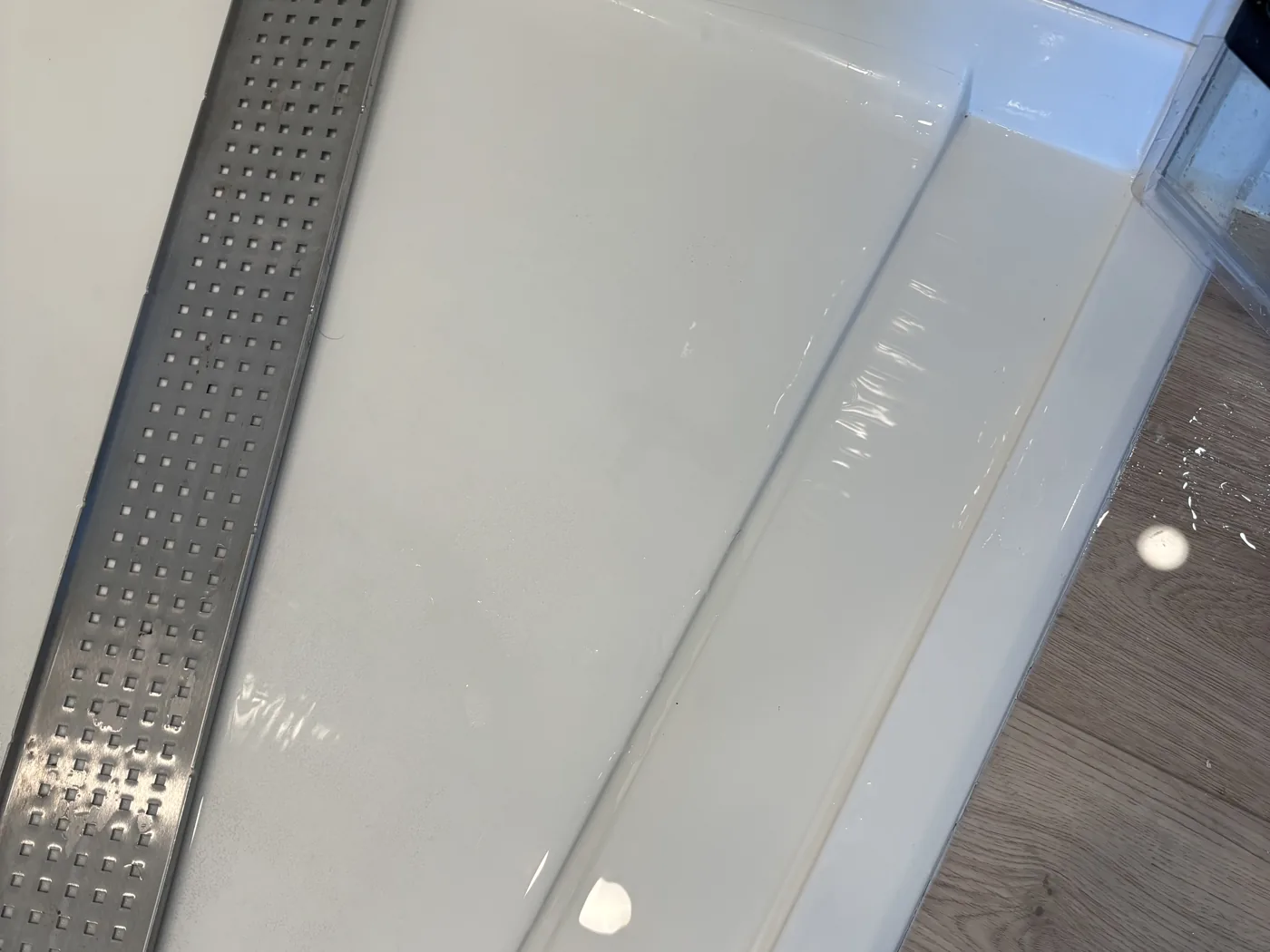 Shower after a deep clean, with white grout lines and the linear drain channel cleaned out