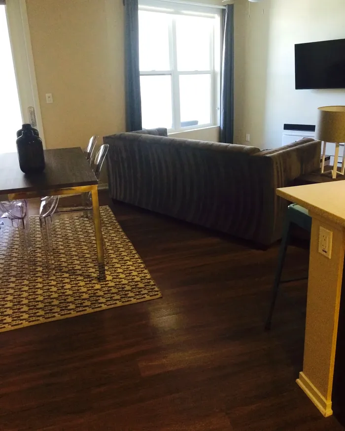 Clean apartment living area with hardwood floors after a visit from White Flowers Cleaning Services