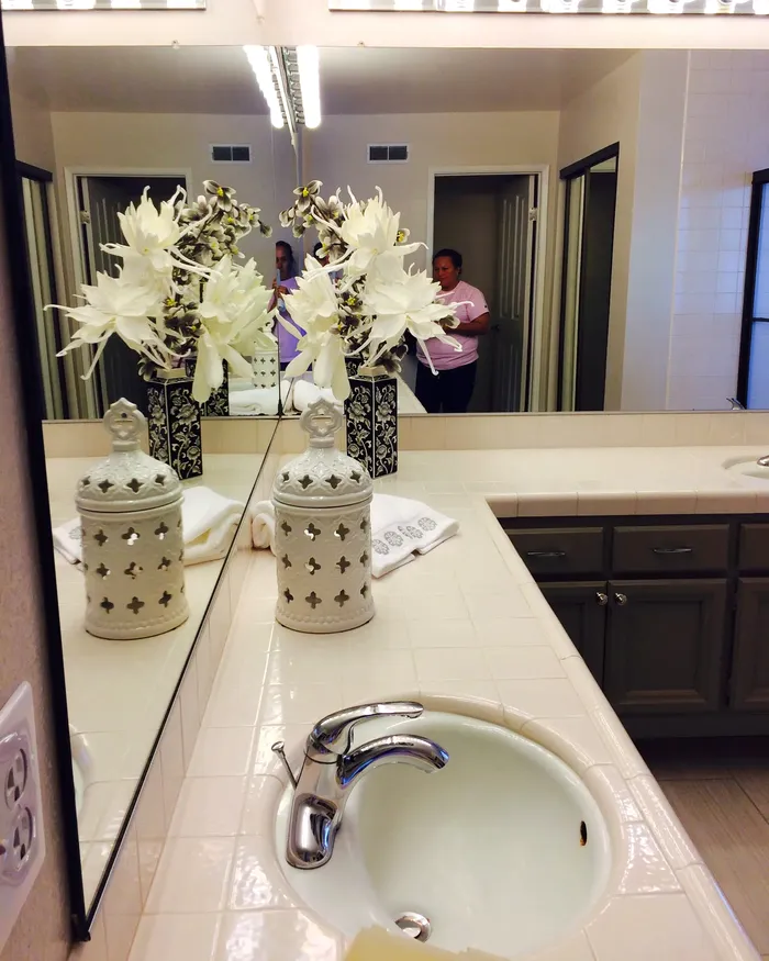 Bathroom vanity and mirror after a deep cleaning by White Flowers Cleaning Services