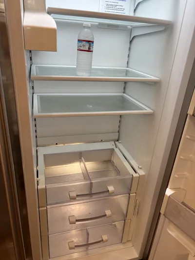 Refrigerator emptied and cleaned inside, shelves and drawers wiped down